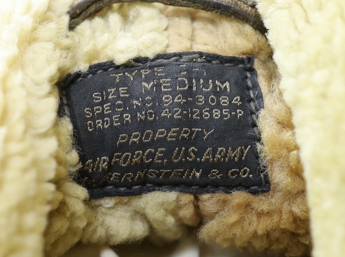 An American US Air Force sheepskin flying jacket, with applied label in collar reading ‘TYPE ….. SIZE MEDIUM SPEC NO. 94-3084 ORDER NO 42-12685-P PROPERTY AIR FORCE U.S. ARMY H. BERNSTEIN & CO.’